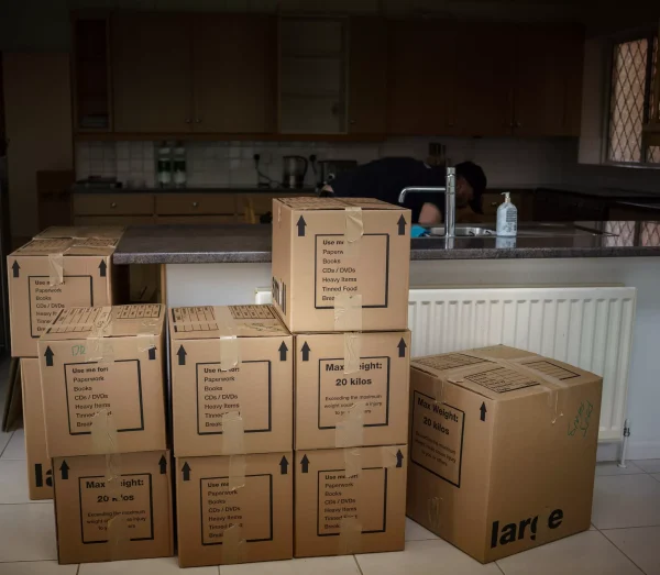 Labeled cardboard moving boxes neatly stacked in a kitchen during a house move