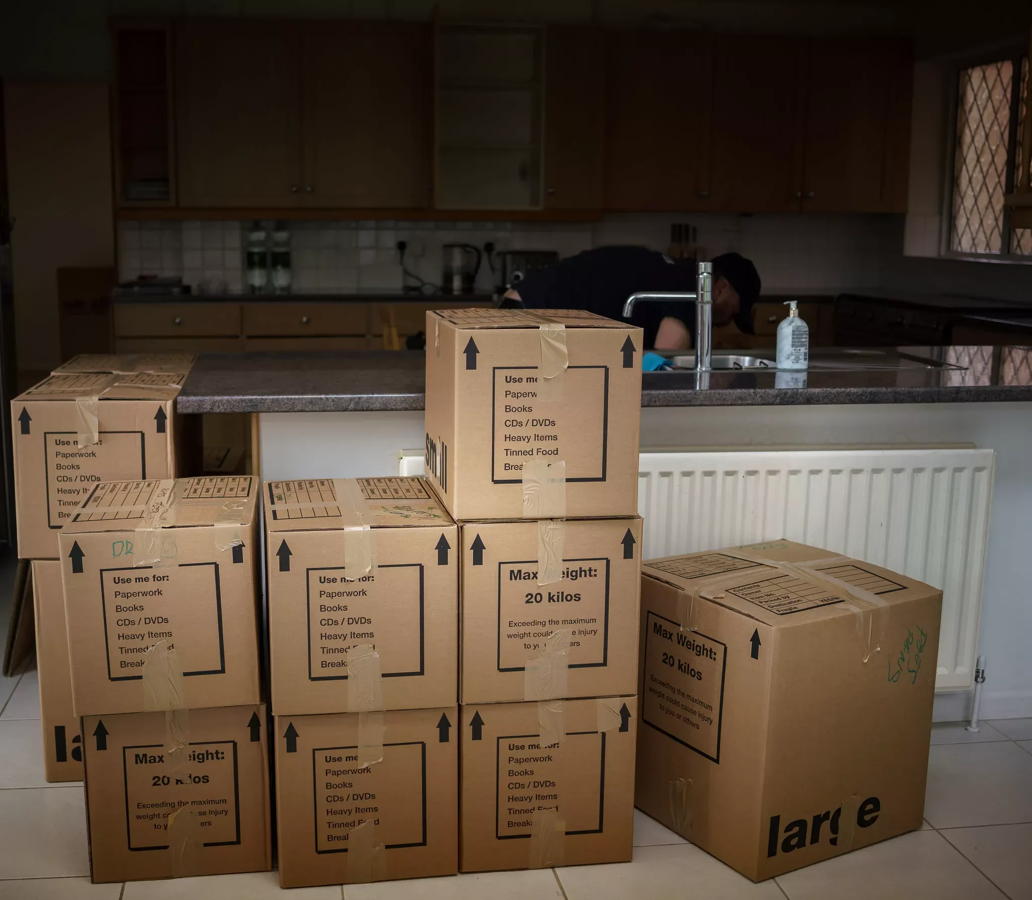 Labeled cardboard moving boxes neatly stacked in a kitchen during a house move