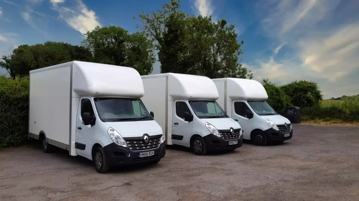 Three white Maxi Mover (Luton) removal vans parked outdoors, part of the Best London Removals fleet.