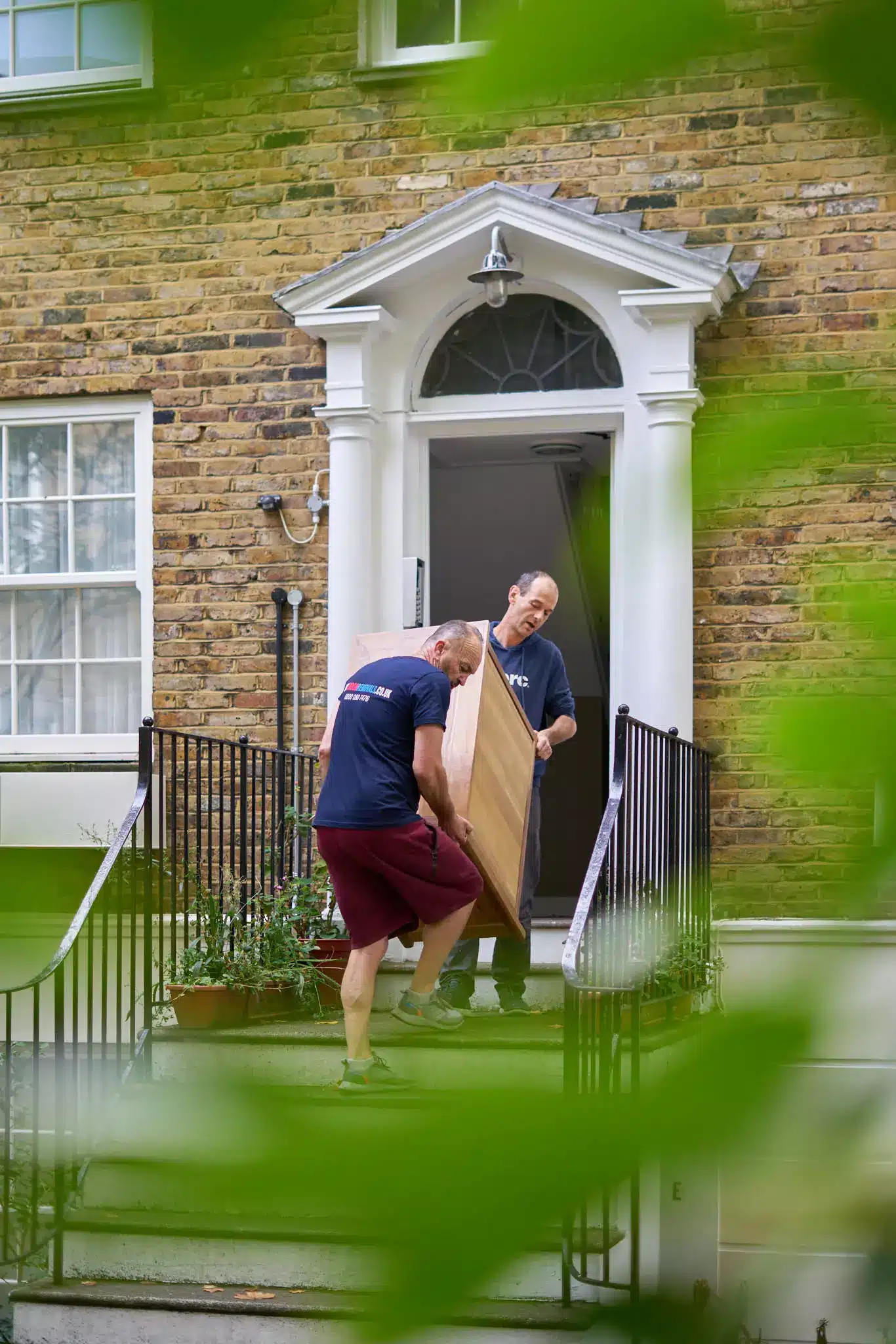 Trusted London Moving Company- 2-man team carrying furniture