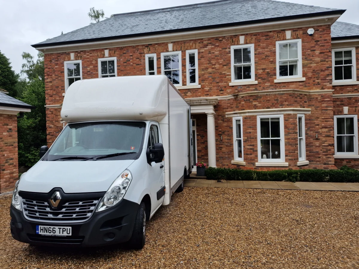 White removal van outside large brick house