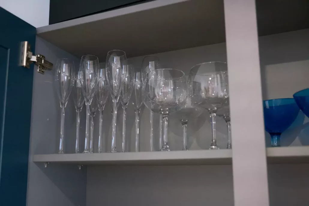 Close-up of wine and champagne glasses neatly stored in a kitchen cabinet before professional packing