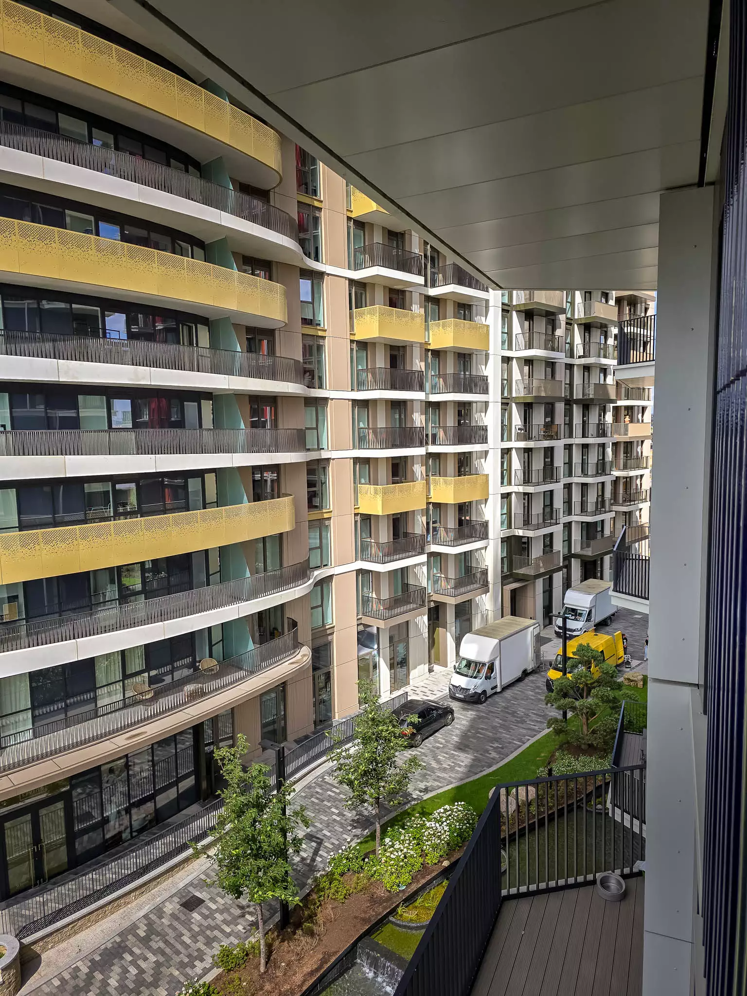 Moving vans parked outside a modern London apartment block for a man and van relocation service