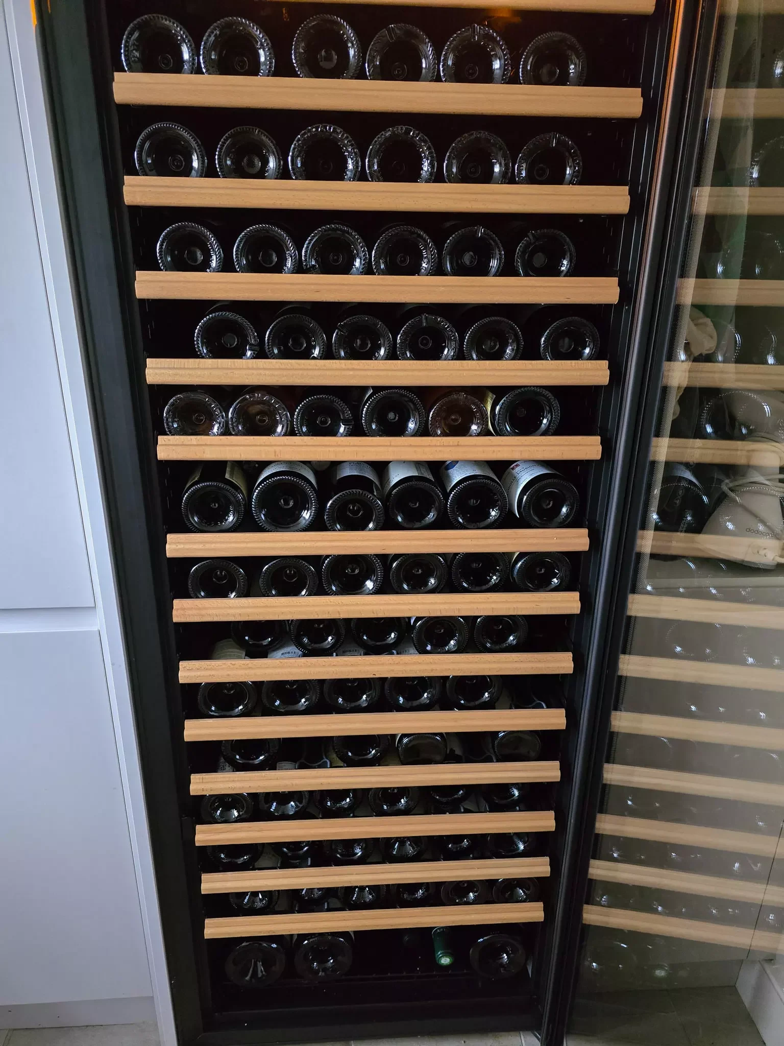 Large wine cooler fully stocked with over 100 bottles prior to removal from 4th floor flat in Kensington