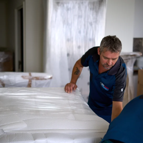Best London Removals moving team wrapping furniture with Furni-guard and plastic protection.
