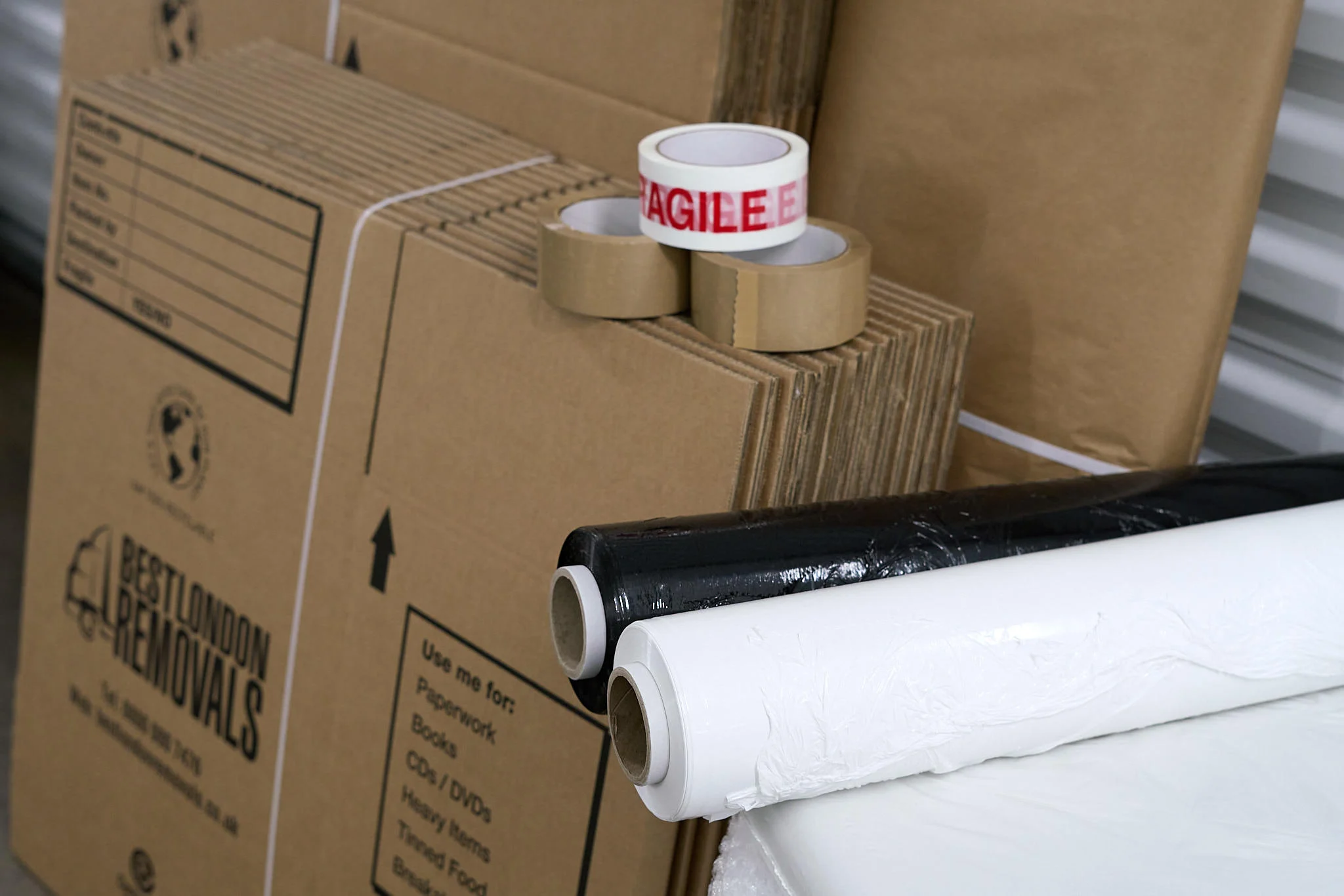 Flat-packed cardboard boxes, fragile tape, stretch wrap and packing materials from Best London Removals