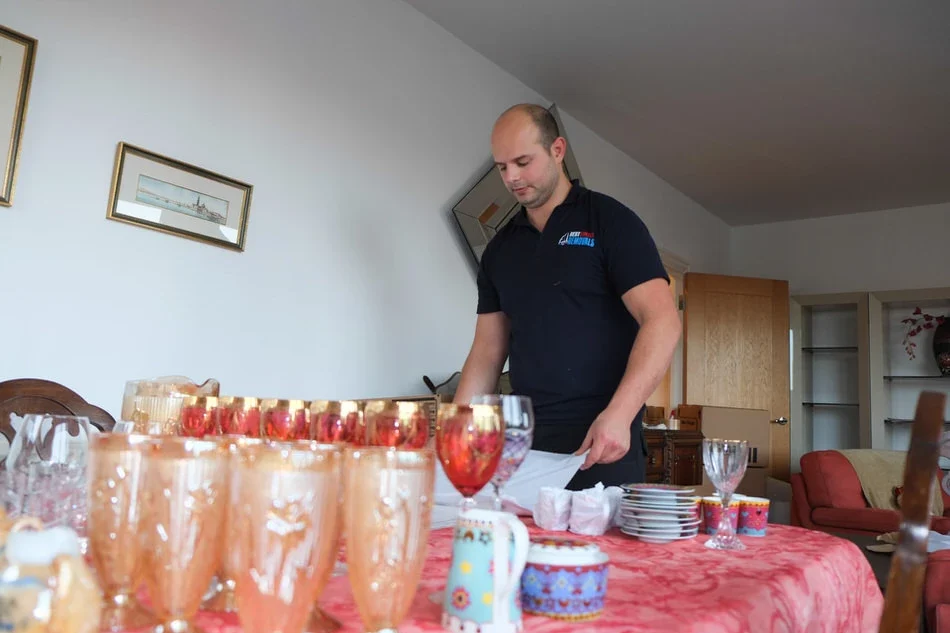 Professional mover packing glassware and kitchen items