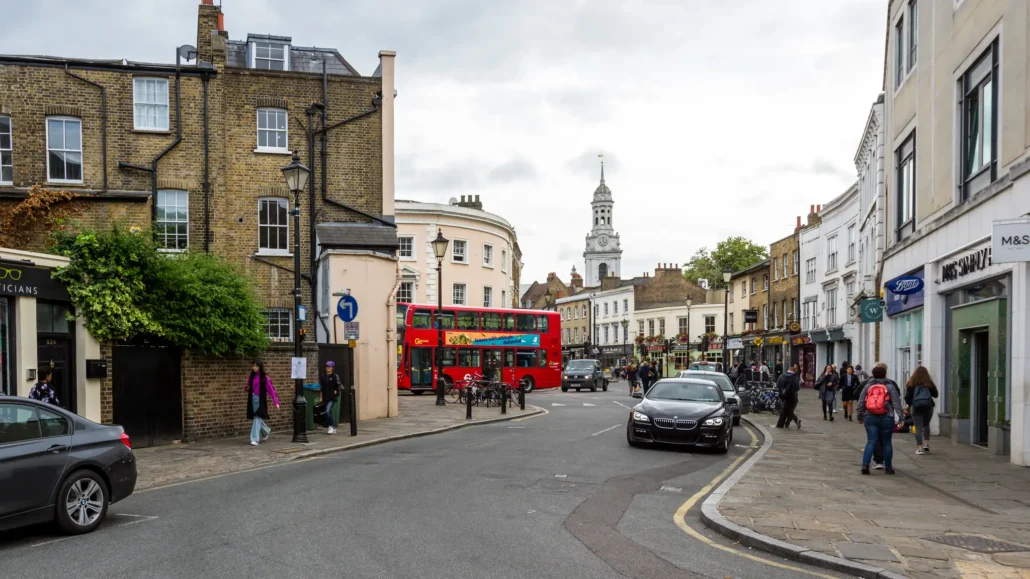 Church Street in Greenwich with a red London bus and the spire of St Alfege Church