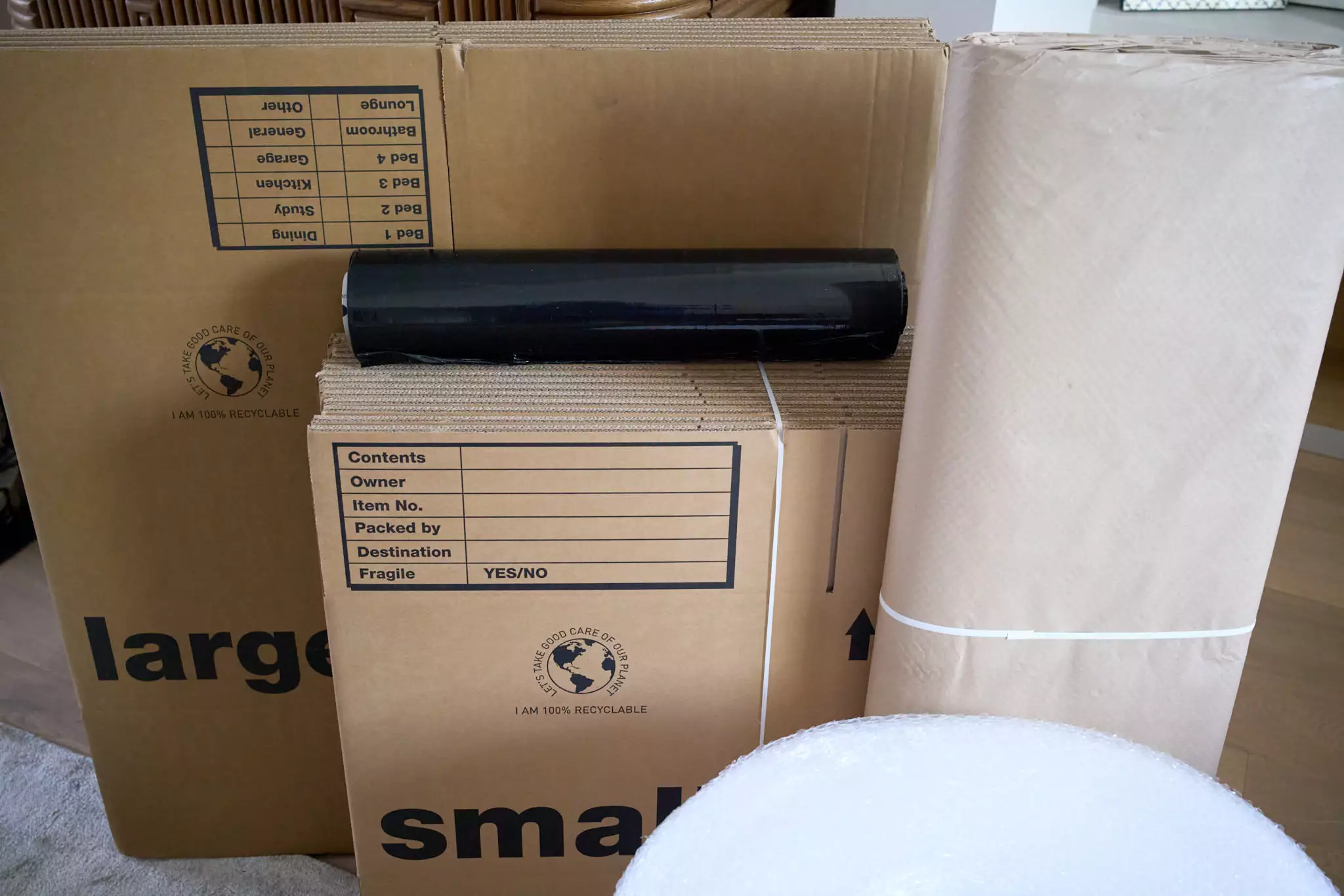 Cardboard boxes, kraft paper roll, black stretch film, and bubble wrap for home removals