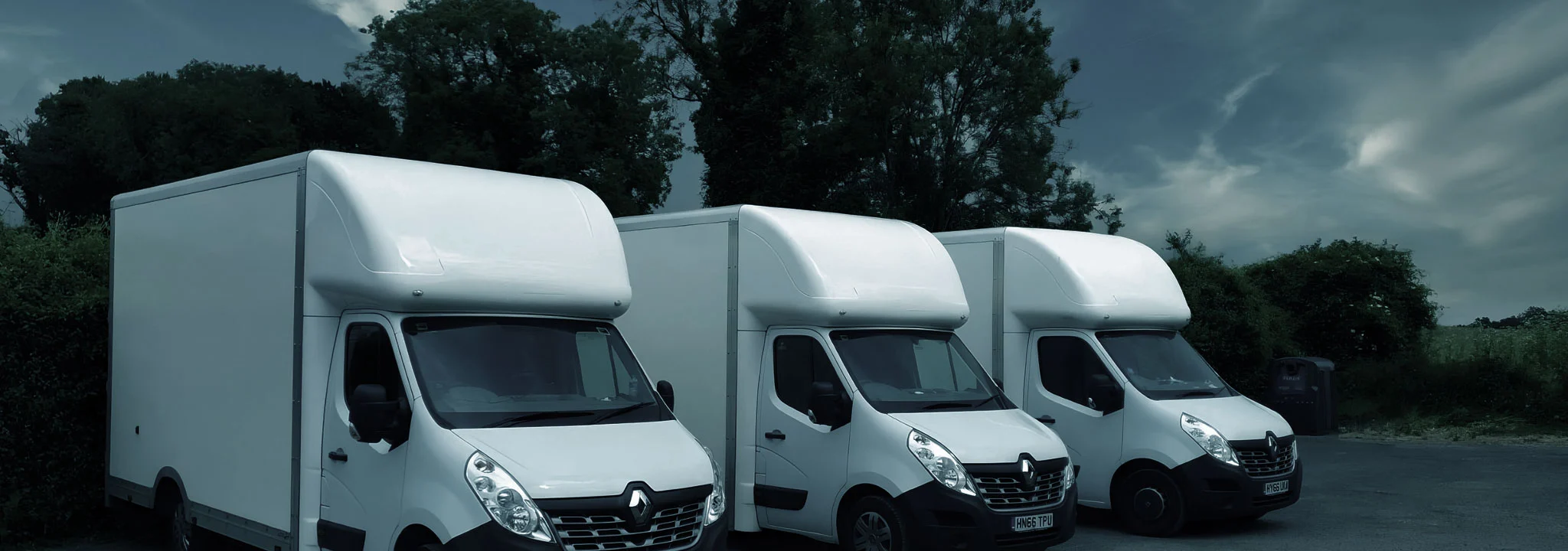 Three white Maxi Mover (Luton) removal vans parked outdoors, part of the Best London Removals fleet.