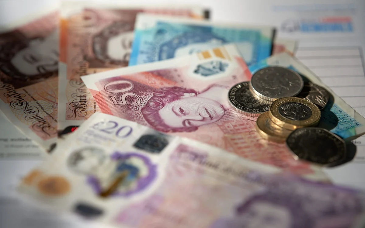 British pound notes and coins on a quote form—representing moving costs and payment options with Best London Removals Ltd