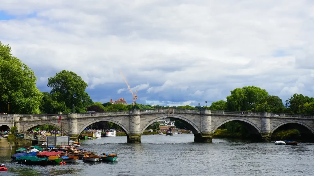 Richmond Bridge over the River Thames with rowing boats moored on the riverside
