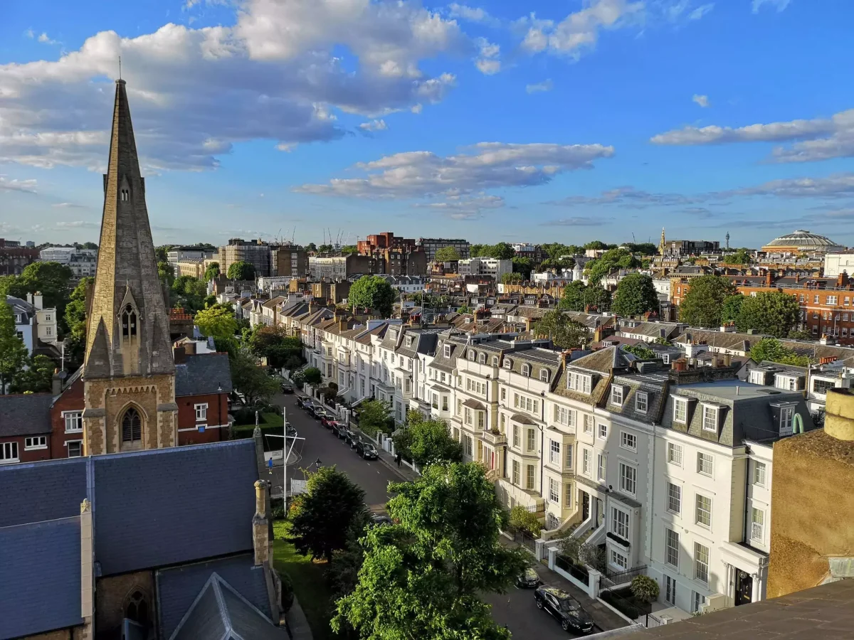 Road between an old church and a row of houses in Chelsea, London. UK