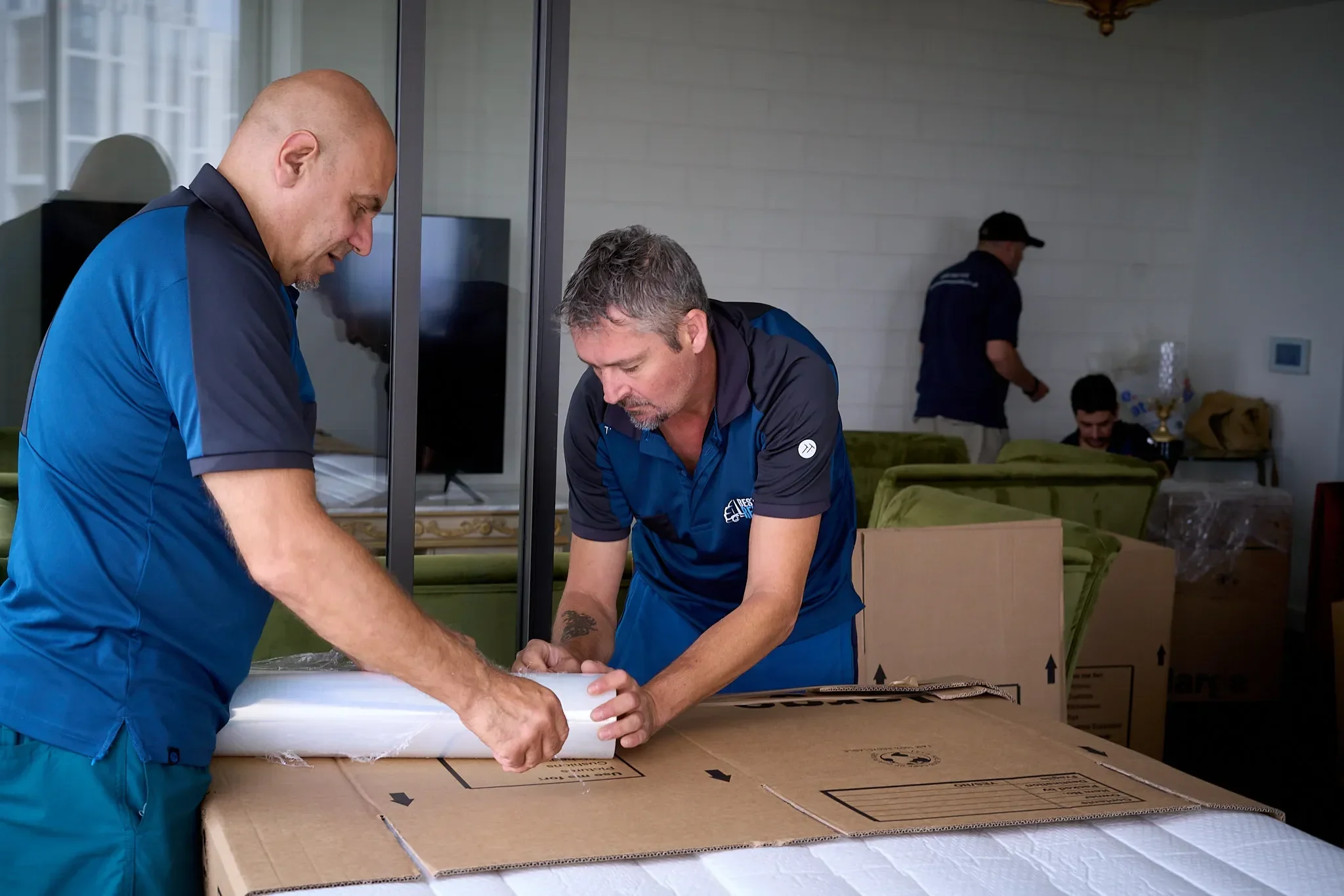 Men packing boxes in a living room.
