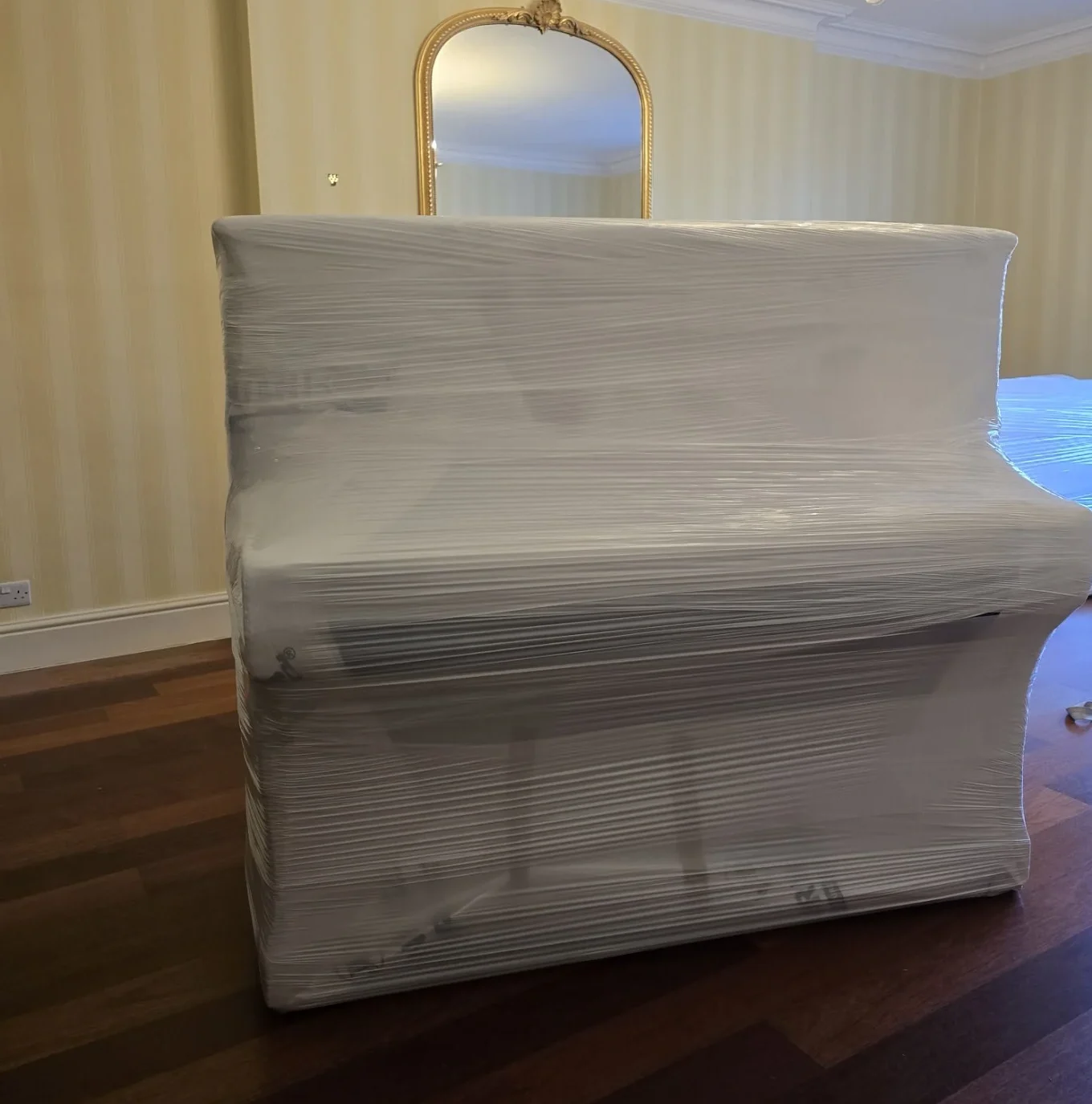 Sofa wrapped in plastic in elegant room